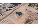 Aerial of gray roof house, gravel driveway with xeriscaping and open desert land at 3887 S 331St Ave, Tonopah, AZ 85354