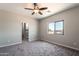 Bedroom with carpet floors, ceiling fan, and access to a bathroom with shower at 3887 S 331St Ave, Tonopah, AZ 85354