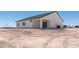 Back of the home with tire tracks in the dirt yard, featuring a covered patio area at 3887 S 331St Ave, Tonopah, AZ 85354