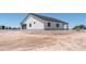 Rear of the house with a gray garage door, a covered patio and potential for custom landscaping at 3887 S 331St Ave, Tonopah, AZ 85354