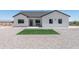 Attractive home exterior with tidy artificial turf, a bench and low-maintenance desert landscaping at 3887 S 331St Ave, Tonopah, AZ 85354