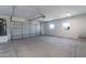 A clean, bright garage with two windows features a roll-up door and concrete floors at 3887 S 331St Ave, Tonopah, AZ 85354