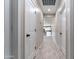 Hallway with tile floor and views into the kitchen with white cabinetry and light countertops at 3887 S 331St Ave, Tonopah, AZ 85354