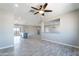 Spacious living room with grey floors, fan, and open access to the kitchen island and bar at 3887 S 331St Ave, Tonopah, AZ 85354