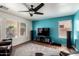 Cozy living room with modern fan, entertainment center, and natural light from the window at 4245 E Shannon St, Gilbert, AZ 85295