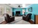 Bright blue living room featuring a ceiling fan, two recliners, and media center at 4245 E Shannon St, Gilbert, AZ 85295