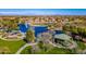 Scenic aerial view of a Primary-planned community with a lake, golf course, and park at 44328 W Knauss Dr, Maricopa, AZ 85138