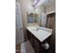 Bathroom with a wide mirror, a single sink and brown cabinets, offering functionality and charm at 44328 W Knauss Dr, Maricopa, AZ 85138