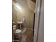Compact bathroom featuring a pedestal sink, tiled floor, and a stylish oval mirror at 44328 W Knauss Dr, Maricopa, AZ 85138