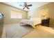 Bedroom offers a ceiling fan, a comfortable bed, and natural light at 44328 W Knauss Dr, Maricopa, AZ 85138