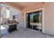 Outdoor covered patio with a gas grill and sliding door access to the home at 44328 W Knauss Dr, Maricopa, AZ 85138
