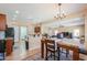Open-concept dining area with a stylish table and views into the living room at 44328 W Knauss Dr, Maricopa, AZ 85138
