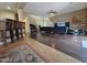 Spacious living room with wood floors, comfortable seating, and a bright, open layout at 44328 W Knauss Dr, Maricopa, AZ 85138