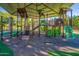 A vibrant playground with climbing structures, slides, and shaded areas, providing a fun and safe play environment at 44328 W Knauss Dr, Maricopa, AZ 85138