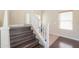 Elegant staircase with dark wood treads and white risers, leading to the upper level at 44328 W Knauss Dr, Maricopa, AZ 85138