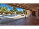 Covered patio providing a view of a sparkling pool, landscaped yard, and brick fire pit at 4442 E Redfield Rd, Phoenix, AZ 85032
