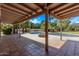 Covered patio providing a view of a sparkling pool, landscaped yard, and brick fire pit at 4442 E Redfield Rd, Phoenix, AZ 85032