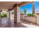 Covered patio with tile flooring and brick accents, showcasing desert landscaping and natural light at 4442 E Redfield Rd, Phoenix, AZ 85032