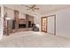 Living room showcasing a brick fireplace, neutral carpet, ceiling fan and a sliding glass door at 4442 E Redfield Rd, Phoenix, AZ 85032