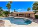 Inviting backyard featuring a pool, covered patio, and mature palm trees, perfect for outdoor entertaining at 4442 E Redfield Rd, Phoenix, AZ 85032