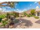 A waterfall in the landscaped backyard is surrounded by mature trees with mountain views in the distance at 5936 W Via Montoya Dr, Glendale, AZ 85310