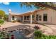 View of a backyard pond and patio, framed by lush plants and the home's covered porch at 5936 W Via Montoya Dr, Glendale, AZ 85310