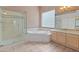 Bathroom features double sinks, a bathtub, walk-in shower, tile floors, and neutral walls at 5936 W Via Montoya Dr, Glendale, AZ 85310