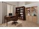 Home office featuring a built-in bookcase, hardwood desk, rolling chair, and neutral walls at 5936 W Via Montoya Dr, Glendale, AZ 85310