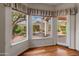 Large windows with decorative curtains provide a view of the beautiful landscaped backyard at 5936 W Via Montoya Dr, Glendale, AZ 85310