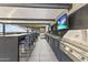 Stylish outdoor kitchen area with a grill, bar seating, and multiple TVs at 7180 E Kierland Blvd # 1218, Scottsdale, AZ 85254