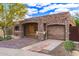 Inviting home featuring stone accents, a wooden front door and an attached garage at 7726 E Kimsey Ln, Scottsdale, AZ 85257