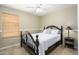 Comfortable bedroom featuring wood laminate flooring, ceiling fan and a black, ornate bed frame at 8331 E Plata Ave, Mesa, AZ 85212