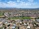 Expansive aerial view of a suburban community featuring well-maintained homes and lush green spaces, set against a mountain backdrop at 856 E Village Cir S Dr, Phoenix, AZ 85022