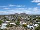 Picturesque aerial view of a residential area, complete with private pools and mountain scenery under a bright, blue sky at 856 E Village Cir S Dr, Phoenix, AZ 85022