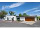 Stunning white exterior with modern wood garage door and desert landscaping under a blue sky at 856 E Village Cir S Dr, Phoenix, AZ 85022
