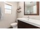 Stylish bathroom with vanity, framed mirror, open shelves, toilet, and bright window at 8845 E Larkspur Dr, Scottsdale, AZ 85260