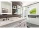 Bathroom with dual sinks, decorative wood paneling, and frameless glass shower enclosure at 8845 E Larkspur Dr, Scottsdale, AZ 85260