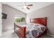 Bedroom with a large window, ceiling fan, and a wooden bed frame with purple patterned bedding at 8845 E Larkspur Dr, Scottsdale, AZ 85260