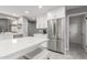 Bright kitchen featuring stainless steel refrigerator, white cabinets and a quartz island with seating at 8845 E Larkspur Dr, Scottsdale, AZ 85260