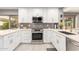 Modern kitchen featuring white cabinets, stainless steel appliances, and tile floors at 8845 E Larkspur Dr, Scottsdale, AZ 85260