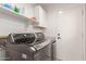 Clean laundry room with modern washer and dryer set and convenient shelving at 8845 E Larkspur Dr, Scottsdale, AZ 85260