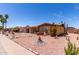 Exterior view of a charming brick home featuring desert landscaping, mature plants and rock features at 962 S Main Dr, Apache Junction, AZ 85120