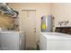 Laundry room with a washer, dryer, utility sink, hot water heater, and access to a backyard at 962 S Main Dr, Apache Junction, AZ 85120