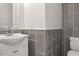 Modern bathroom features gray tiled walls, a stylish vanity, and contemporary fixtures at 11983 W Fillmore St, Avondale, AZ 85323