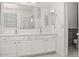 Bright bathroom featuring double sinks, large mirror, and white cabinets at 11983 W Fillmore St, Avondale, AZ 85323