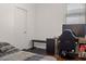 A bedroom with a bed, desk and gaming equipment with natural light from a window at 11983 W Fillmore St, Avondale, AZ 85323
