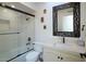 Bathroom with shower over tub, patterned mirror, white walls, toilet, and ample lighting fixtures at 1302 E Nicolet Ave, Phoenix, AZ 85020