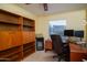 Functional bedroom area with built-in bookshelves, personal mini-fridge, neutral carpet, and personal workspace at 1302 E Nicolet Ave, Phoenix, AZ 85020