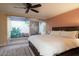 Cozy main bedroom featuring private patio view, neutral color palette, plush carpeting, and decorative ceiling fan at 1302 E Nicolet Ave, Phoenix, AZ 85020