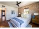 Comfortable bedroom boasting an exposed brick accent wall, ceiling fan, and plush bedding for ultimate relaxation at 1546 W Culver St, Phoenix, AZ 85007